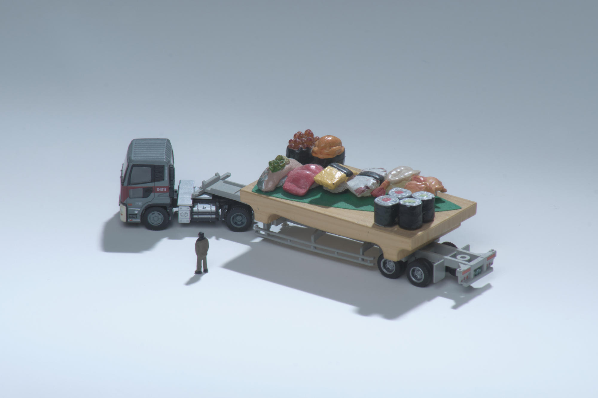 Man inspects flatbed truck carrying sushi.
